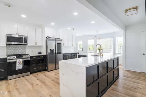 a large kitchen with a table and chairs