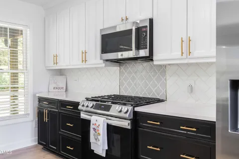 a kitchen with stainless steel appliances kitchen island granite countertop a refrigerator a sink dishwasher a stove and a dining table with wooden floor