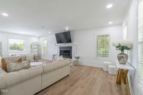 a living room with furniture a fireplace and a flat screen tv
