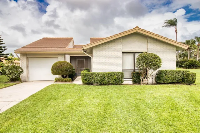 a front view of a house with yard and garage