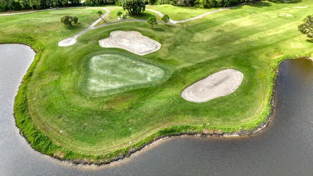 an aerial view of a house with a garden and lake view