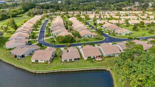 an aerial view of residential houses with outdoor space and trees