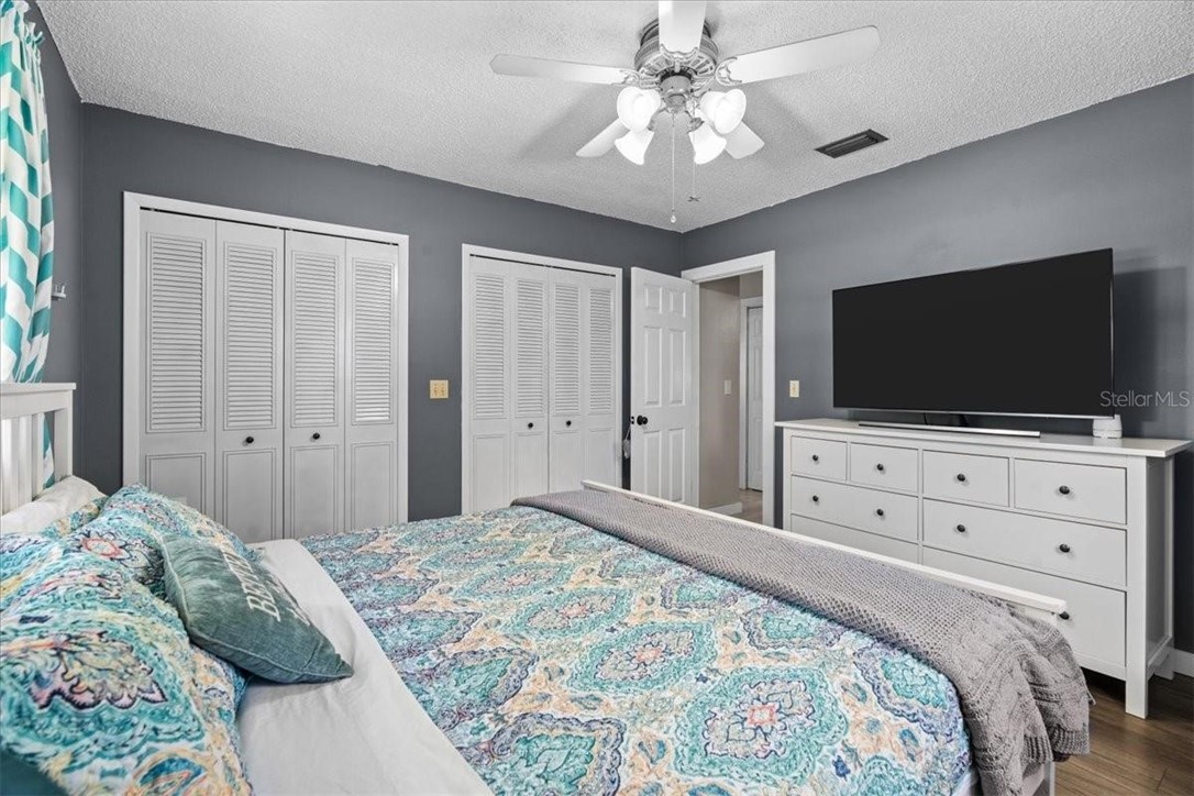 424 Wisconsin Avenue St. Cloud, FL 34769 - Photo 18 of 36 a bedroom with a bed room that has a flat screen tv and a chandelier