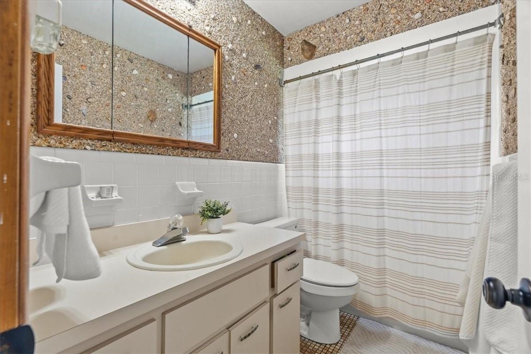 424 Wisconsin Avenue St. Cloud, FL 34769 - Photo 21 of 36 a bathroom with a sink a toilet and mirror