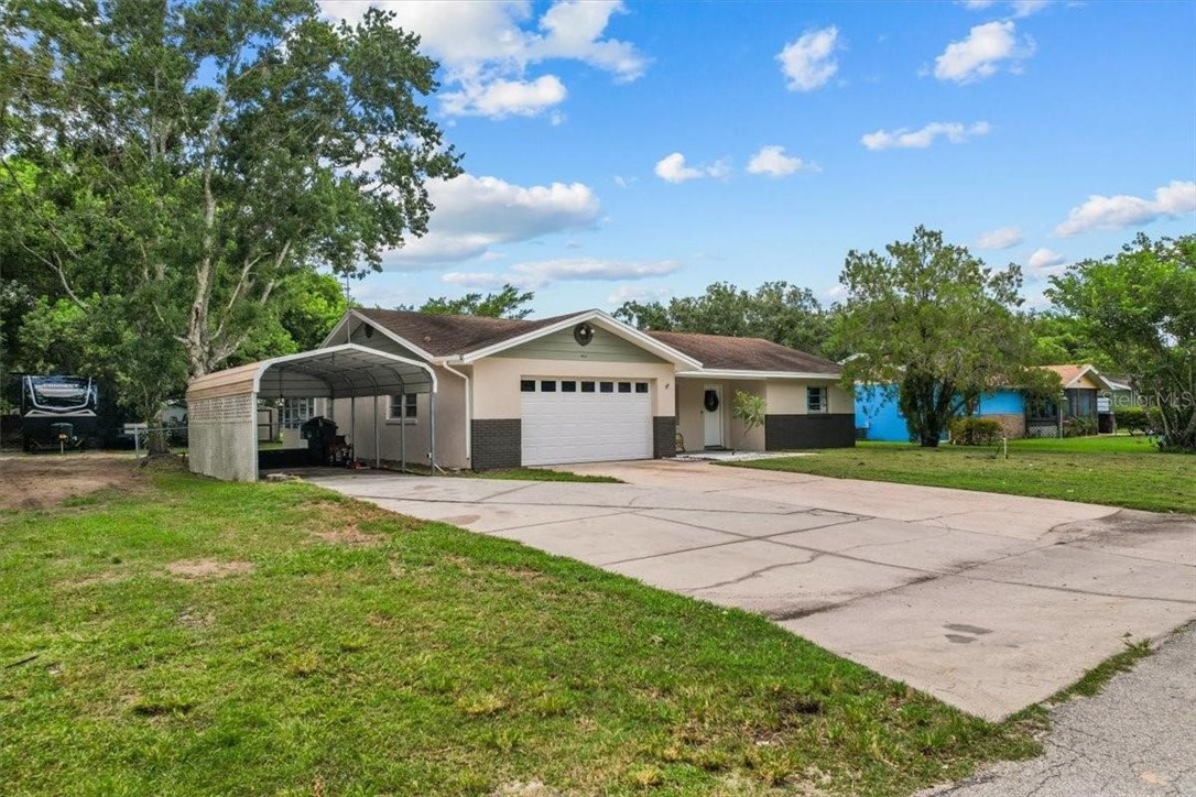 424 Wisconsin Avenue St. Cloud, FL 34769 - Photo 28 of 36 a front view of a house with a yard and garage