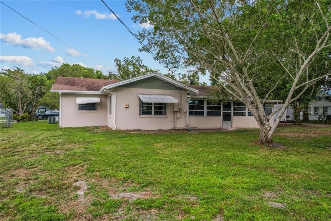 424 Wisconsin Avenue St. Cloud, FL 34769 - Photo 32 of 36 a backyard of a house with plants and large tree