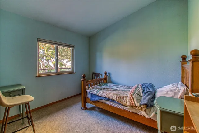 a bedroom with a bed and a tv on the dresser