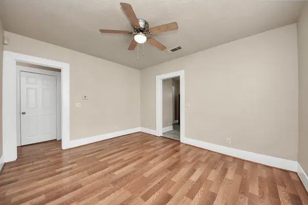 a view of an empty room with wooden floor