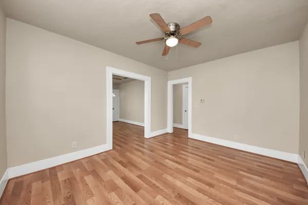a view of an empty room with wooden floor