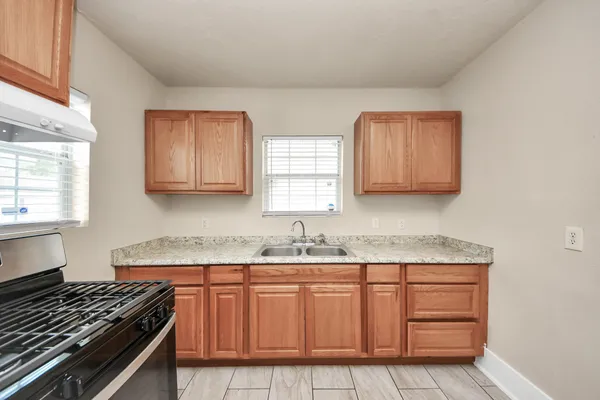 a kitchen with stainless steel appliances granite countertop a sink stove and cabinets