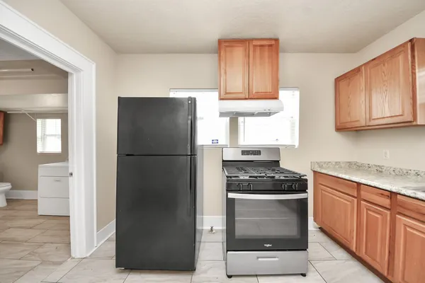 a kitchen with a refrigerator and a stove top oven