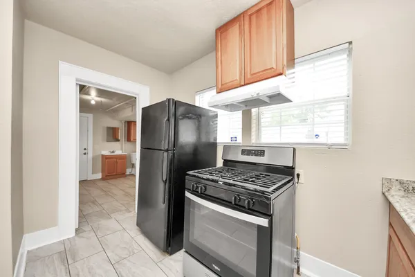 a kitchen with stainless steel appliances granite countertop a refrigerator and a stove