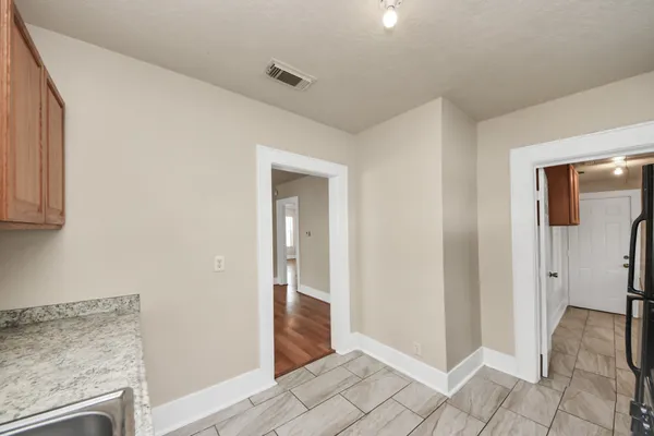 a view of a hallway with bathroom and wooden floor