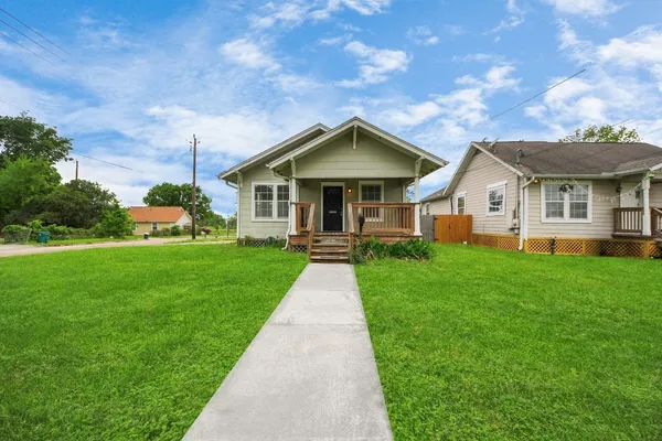 a front view of a house with a yard and potted plants