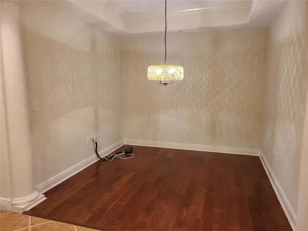 a view of a room with wooden floor and chandelier