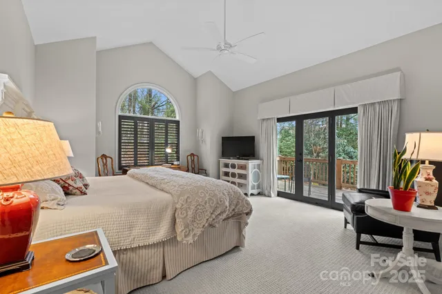 a bedroom with a balcony a bed and a flat screen tv