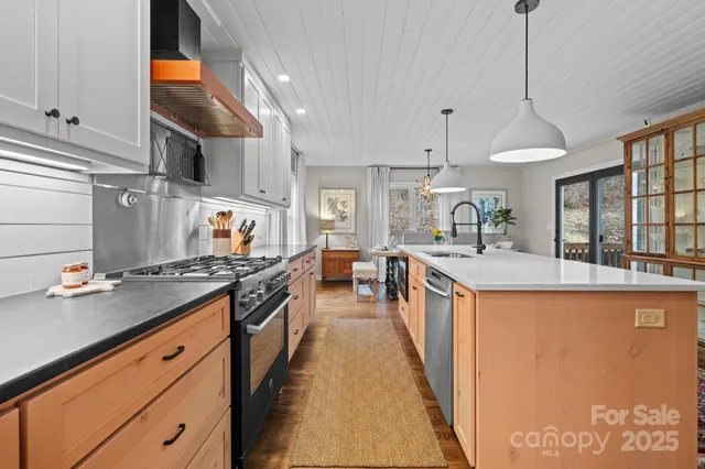 a large kitchen with stainless steel appliances granite countertop a stove and a sink