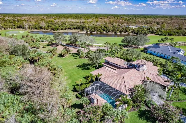 an aerial view of a house with swimming pool patio and lake view