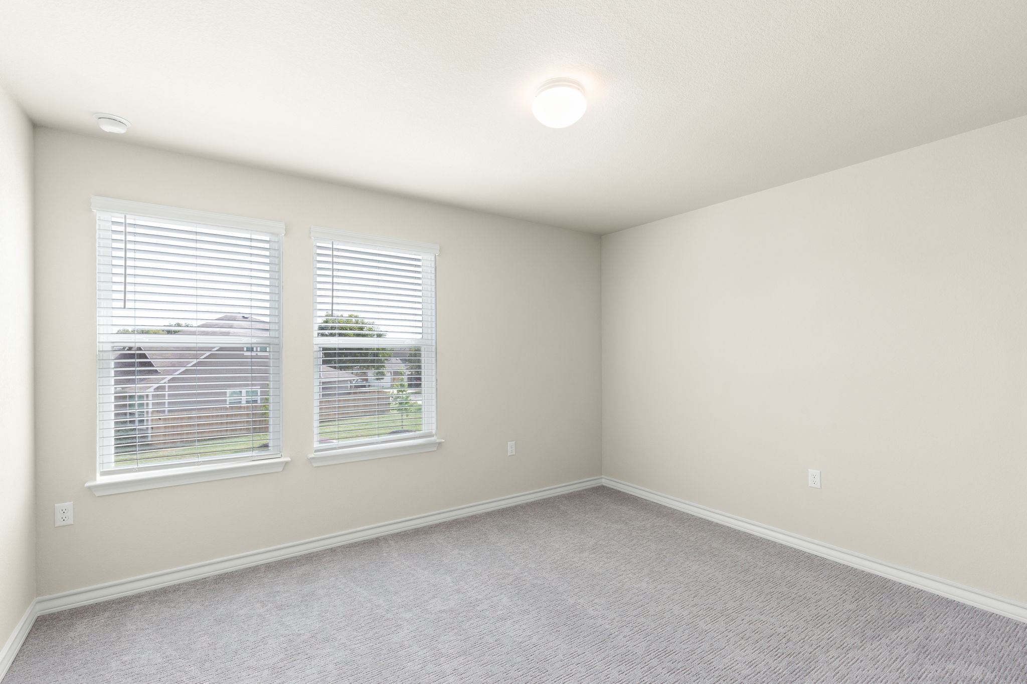 1624 Caballo Blanco Road Austin, TX 78725 - Photo 23 of 27 Plush carpeting and dual windows enhance this versatile secondary bedroom space.