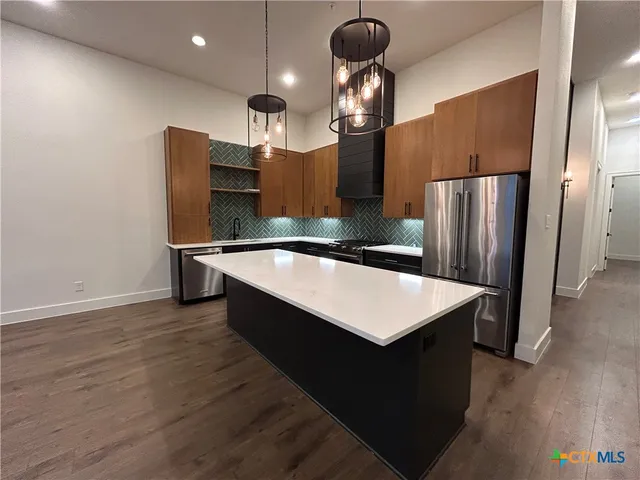 a kitchen with stainless steel appliances a refrigerator and a stove