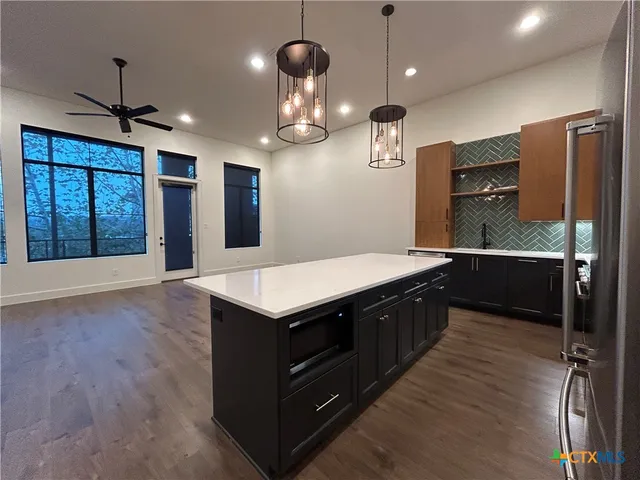 a kitchen with a counter space cabinets and wooden floor