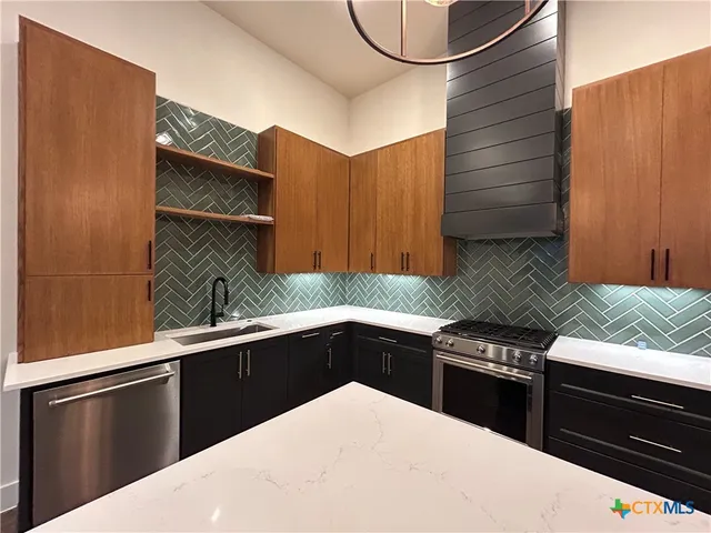 a kitchen with a sink and a stove top oven
