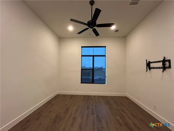 a view of empty room with wooden floor