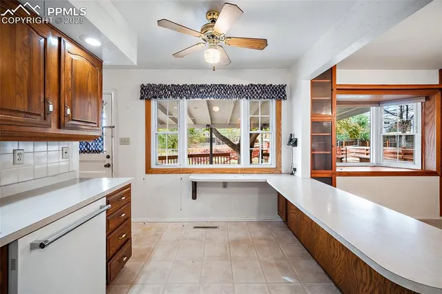 a large kitchen with kitchen island a large window a sink and stainless steel appliances