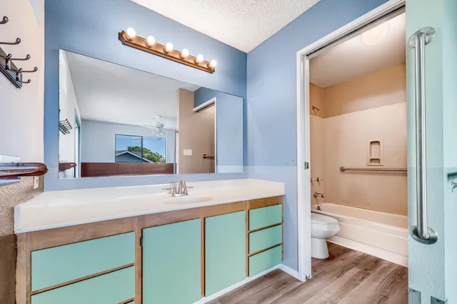 a bathroom with a sink a toilet and shower