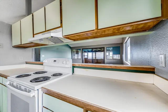 a kitchen with a stove and a white cabinets
