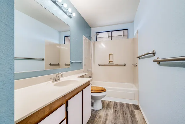 a bathroom with a sink a toilet a mirror and shower