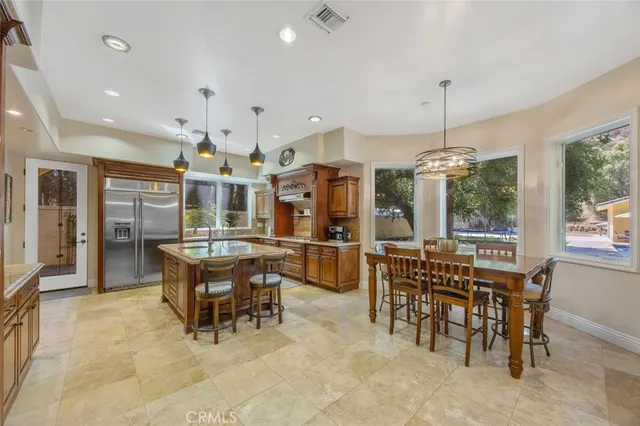 a dining hall with stainless steel appliances granite countertop a stove and a dining table with the kitchen view