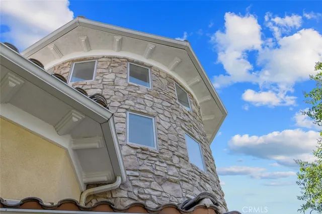 a view of a house with potted plants and a large tree