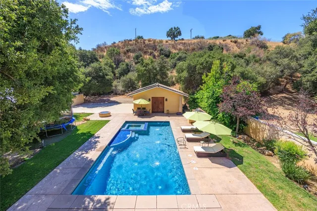 a view of a garden with swimming pool and sitting area
