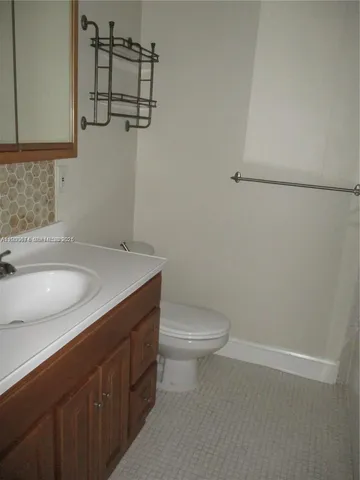 a bathroom with a granite countertop sink toilet and vanity
