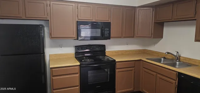 a kitchen with appliances a sink and cabinets