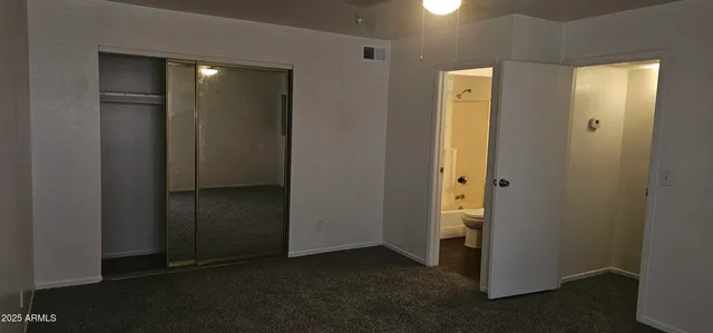 an empty room with closet and mirror