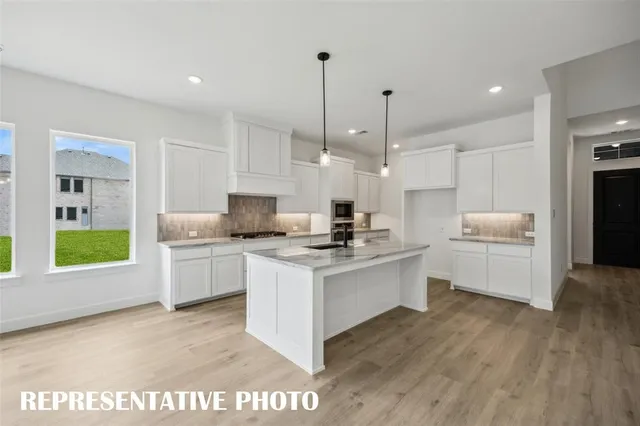 a view of kitchen with stainless steel appliances granite countertop stove top oven and cabinets