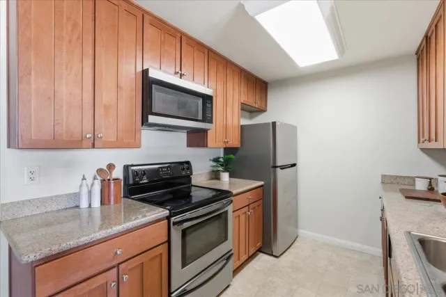 a kitchen with stainless steel appliances granite countertop a stove a sink and a microwave