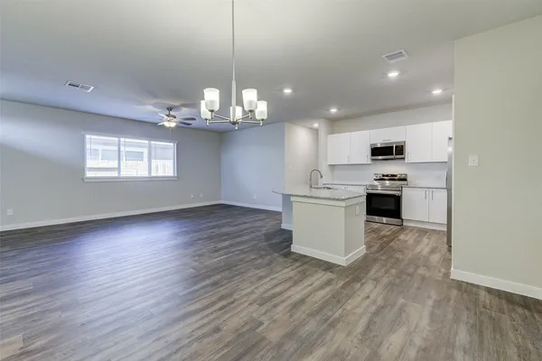 a view of kitchen with granite countertop cabinets and refrigerator