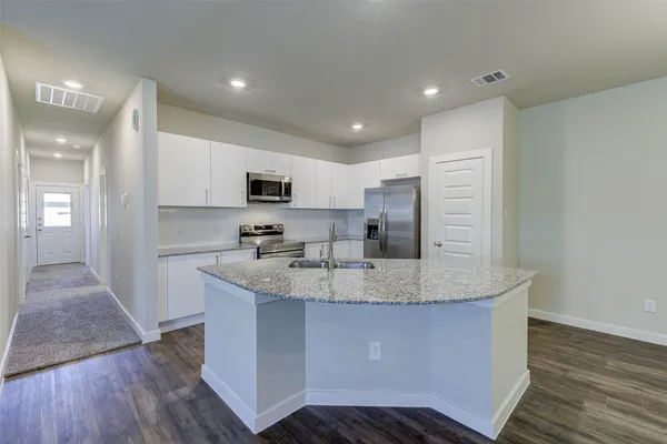 a kitchen with stainless steel appliances a stove sink microwave and refrigerator