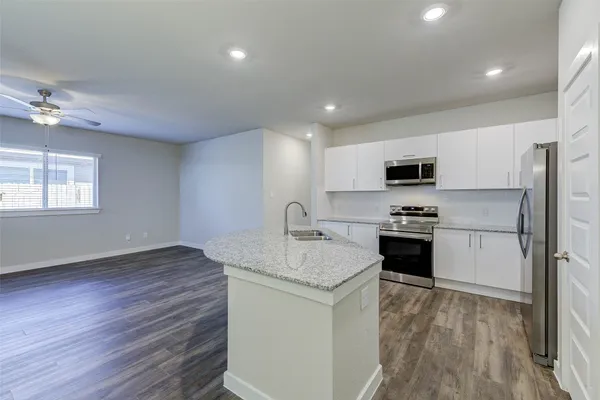 a kitchen with kitchen island a counter top space cabinets and stainless steel appliances