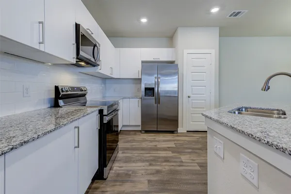 a kitchen with granite countertop a sink and a stove top oven
