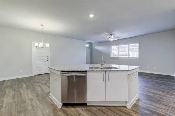 a kitchen with granite countertop a refrigerator stove and sink