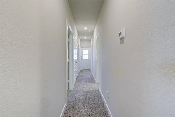 an empty room with a chandelier fan and windows