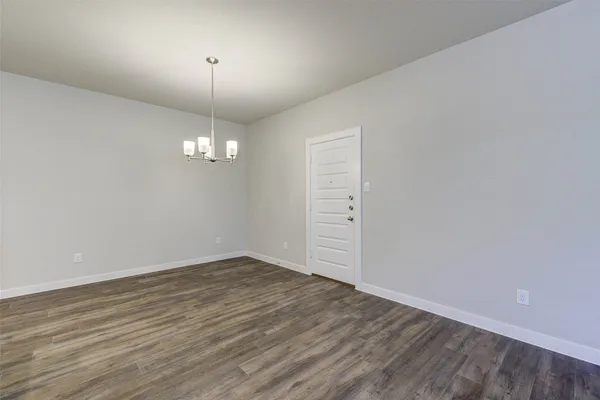 a large kitchen with stainless steel appliances granite countertop a stove top oven a sink dishwasher and white cabinets with wooden floor