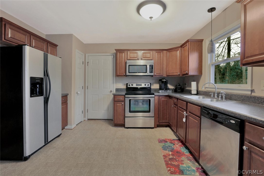 4106 Paces Ferry Road Chester, VA 23831 - Photo 5 of 23 a kitchen with stainless steel appliances granite countertop a refrigerator a sink a stove a microwave and wooden cabinets