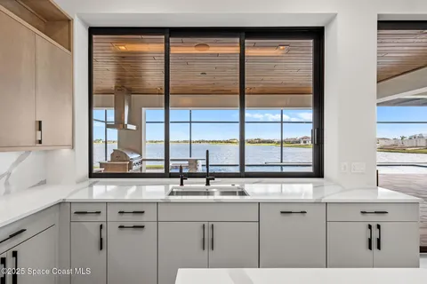 a large white kitchen with a large window