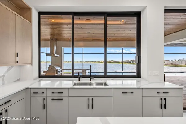 a large white kitchen with a large window