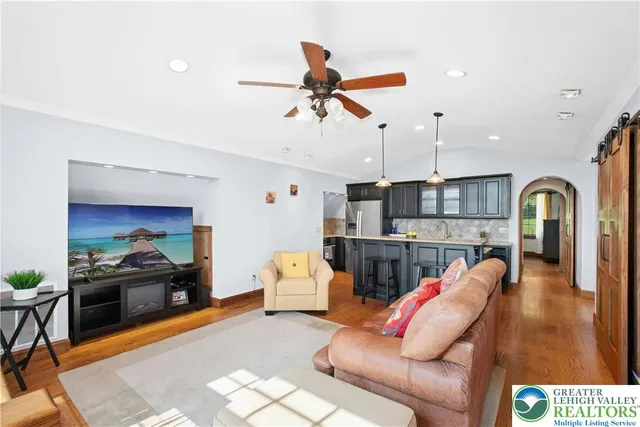 a kitchen with a stove a sink a refrigerator and chairs